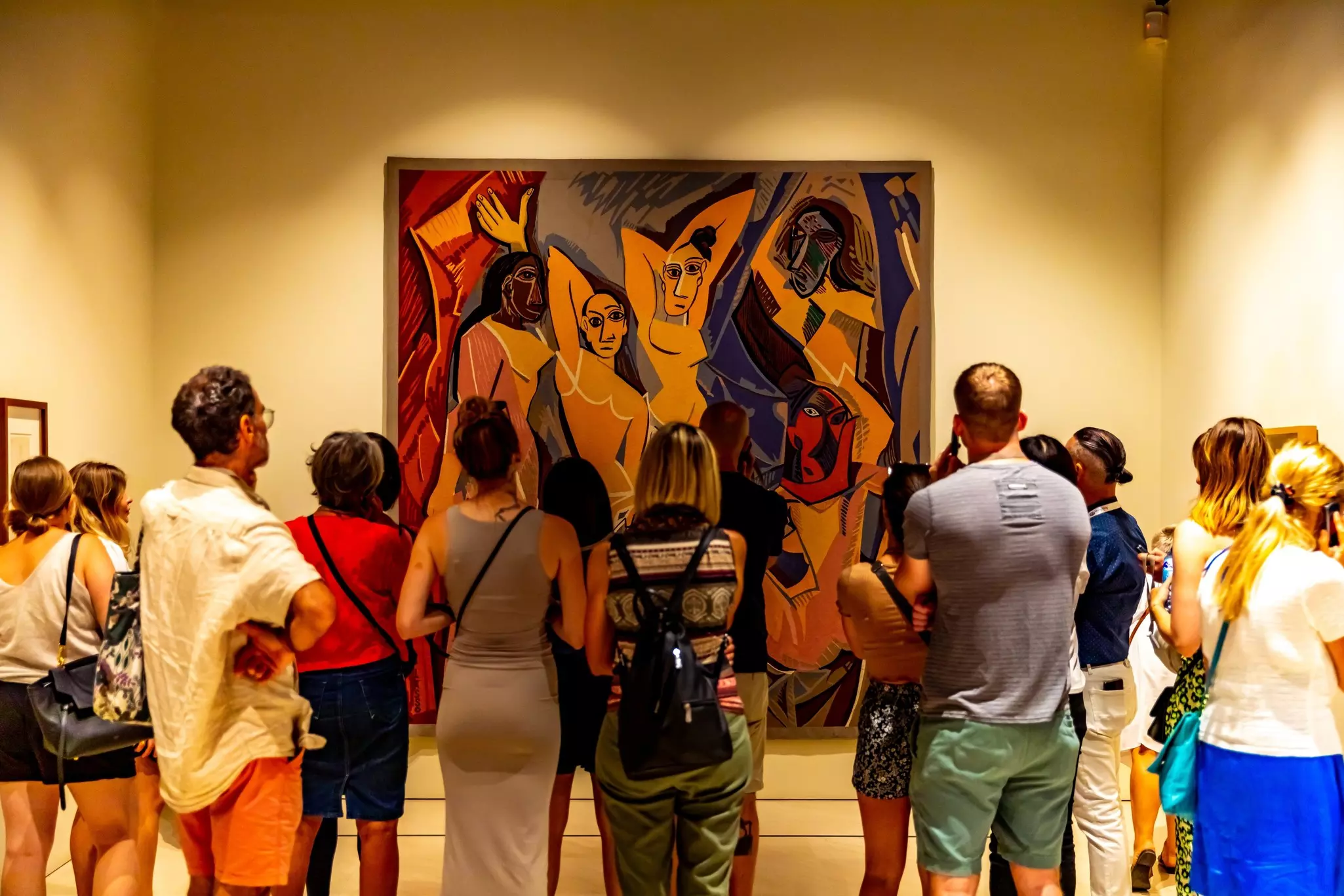 Museum visitors looking at a large Picasso painting of four people