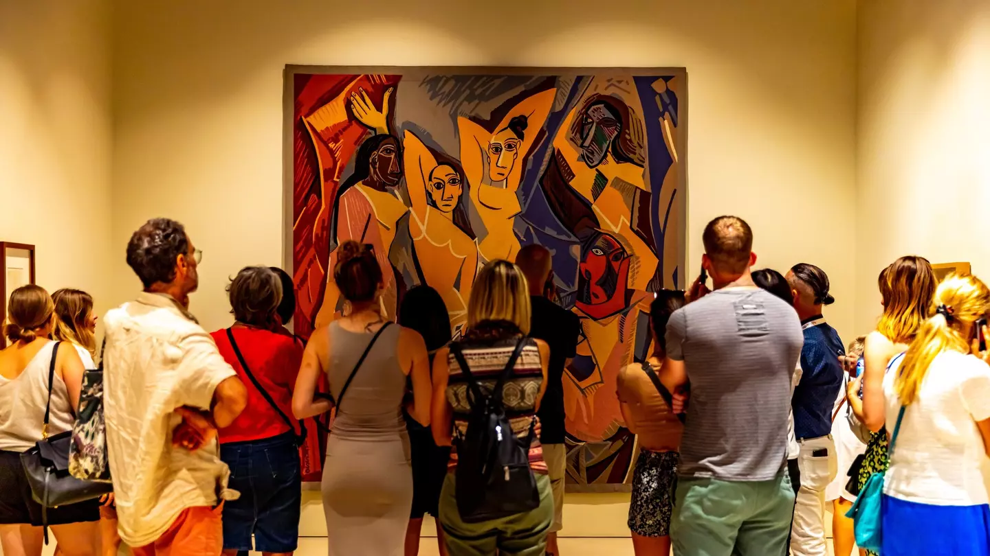 Museum visitors looking at a large Picasso painting of four people