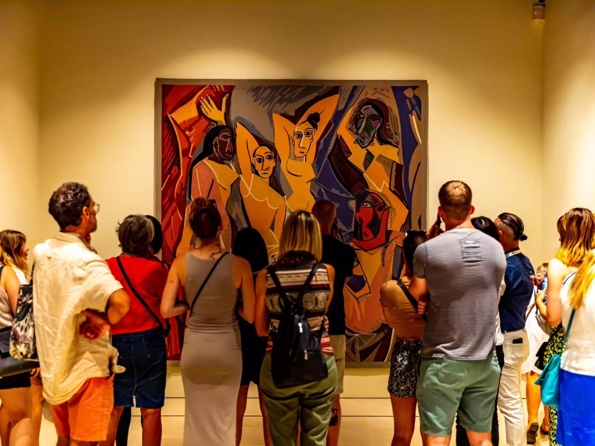 Museum visitors looking at a large Picasso painting of four people