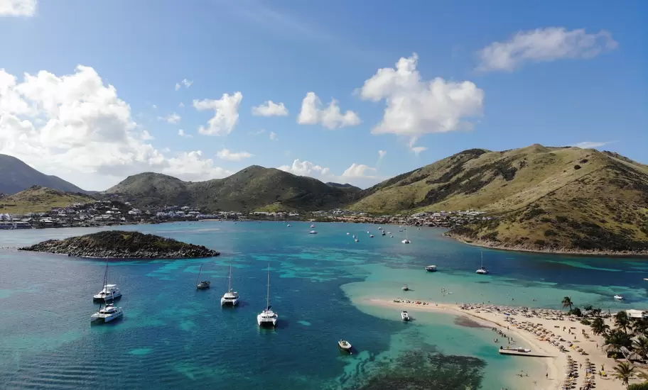 Aerial view of Pinel Island beach, St-Martin, with anchored yachts, reefs and the green hills of Cul-de-Sac across the bay