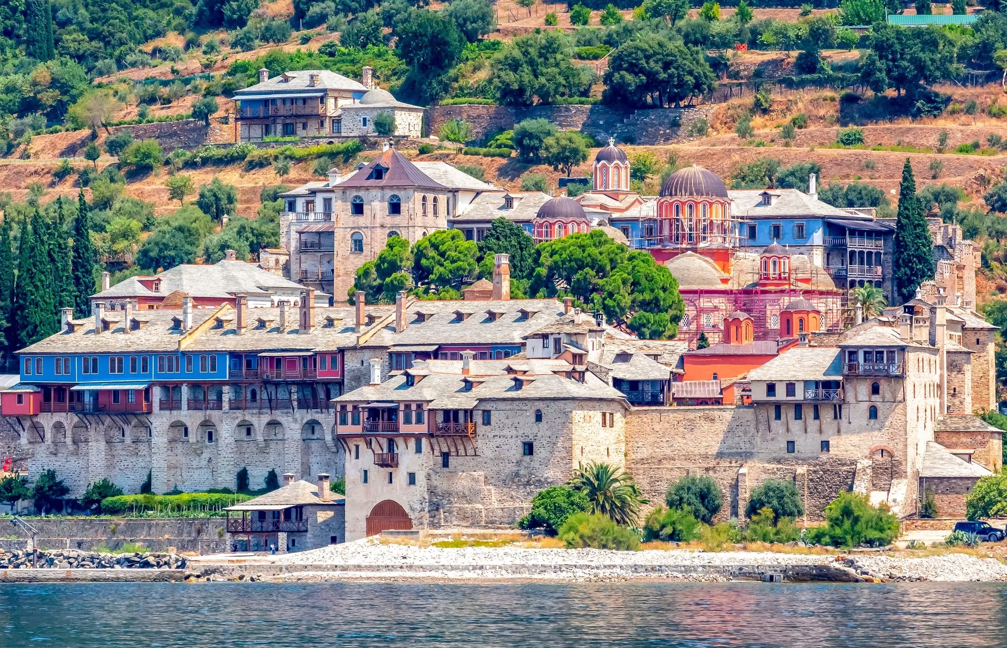 The stone buildings of a monastery complex next to the water