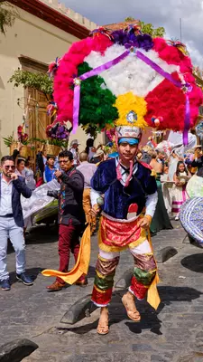 A man dancing in feathered attire. 