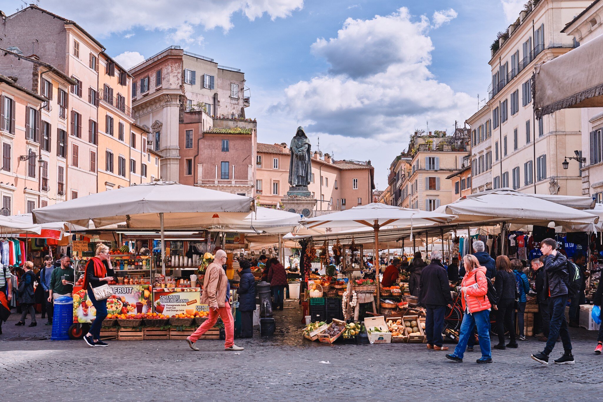 March 8, 2018: Traditional outdoor food market of Campo de Fiori (fields of flower), with the statue of Giordano Bruno in the background.