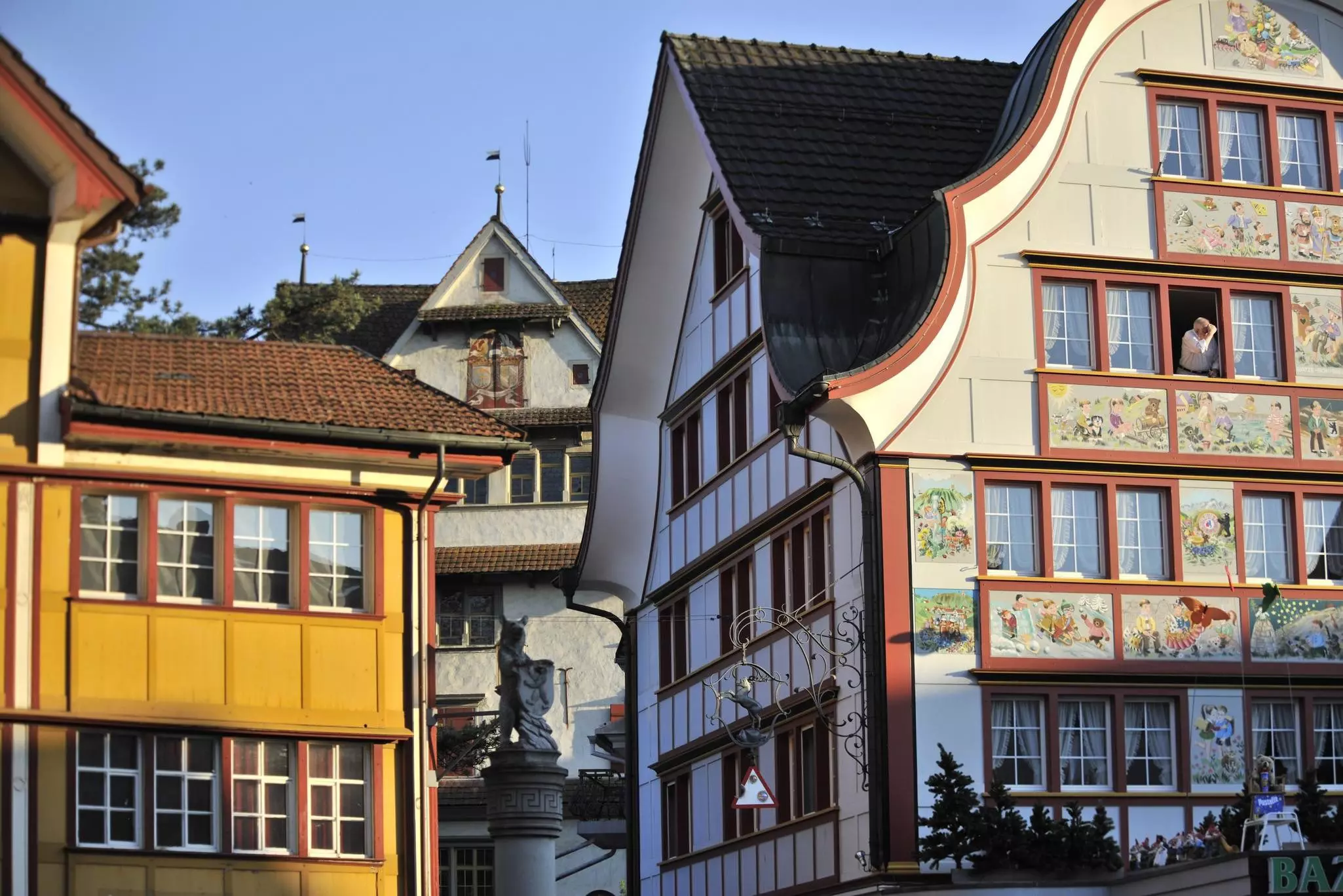 Traditionally styled buildings in Switzerland, one with different scenes painted on its panels