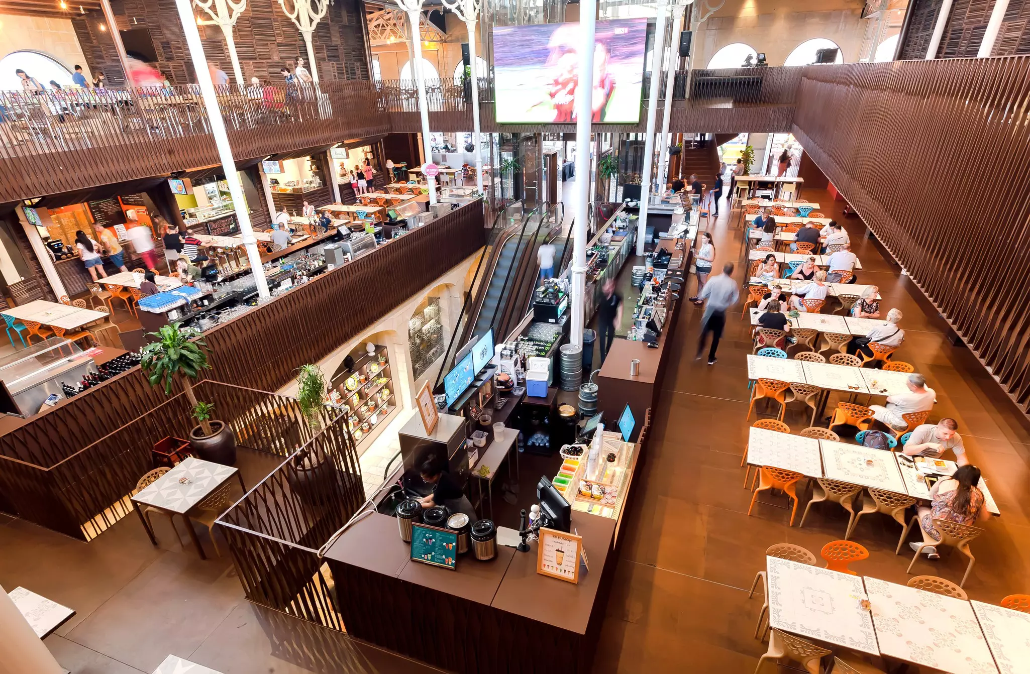 People eating dinner inside the covered market Is-Suq Tal-Belt, with different eateries in a communal area