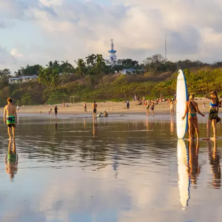 Beach-goers gather along the shore at Playa Guiones.