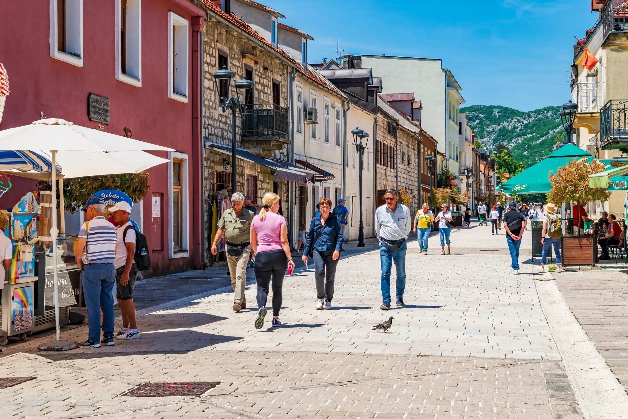 People wander down a pedestrianized street in a town: Cetinje, Montenegro