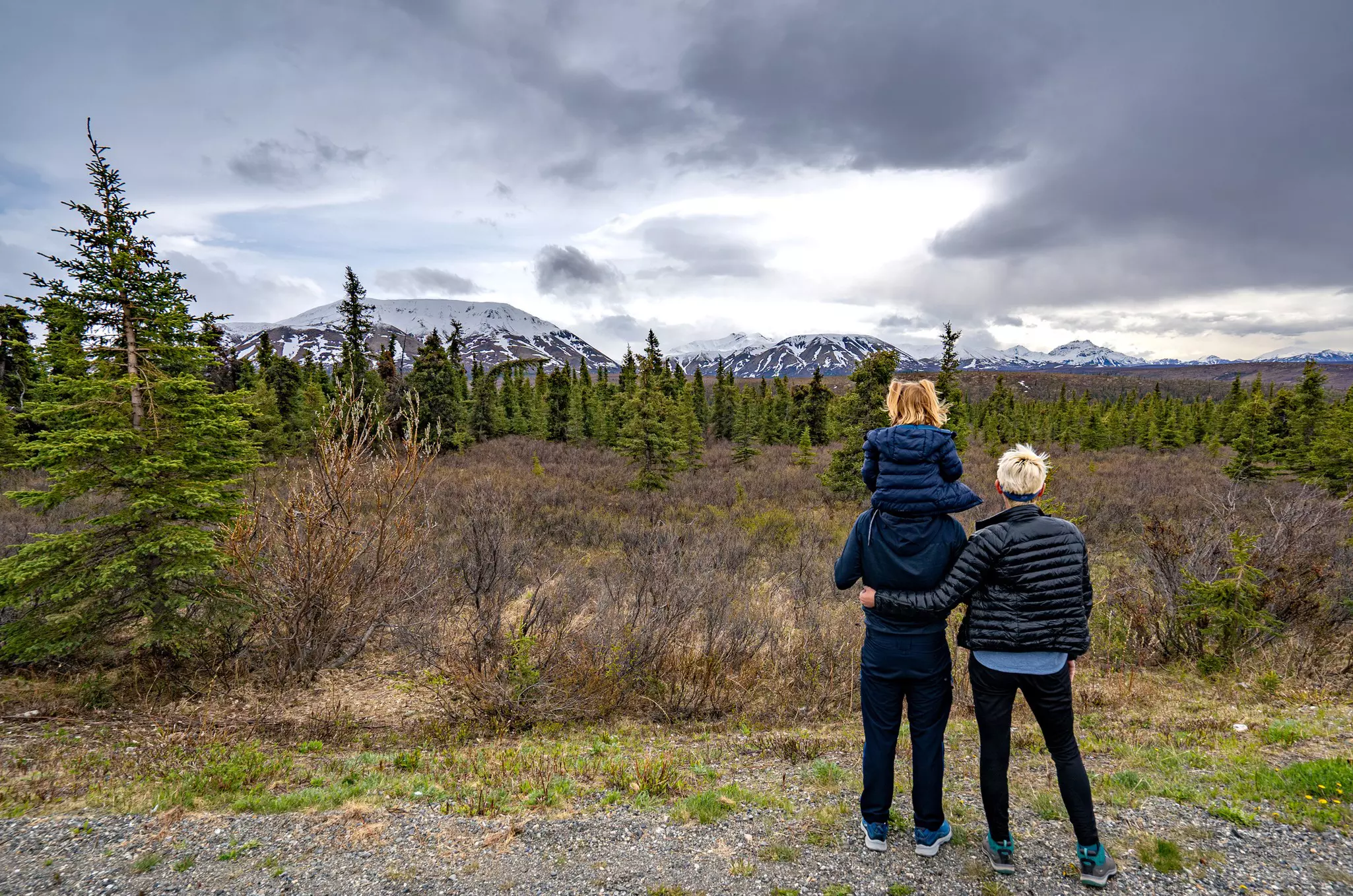 Two parents and a child enjoying some mountain scenery