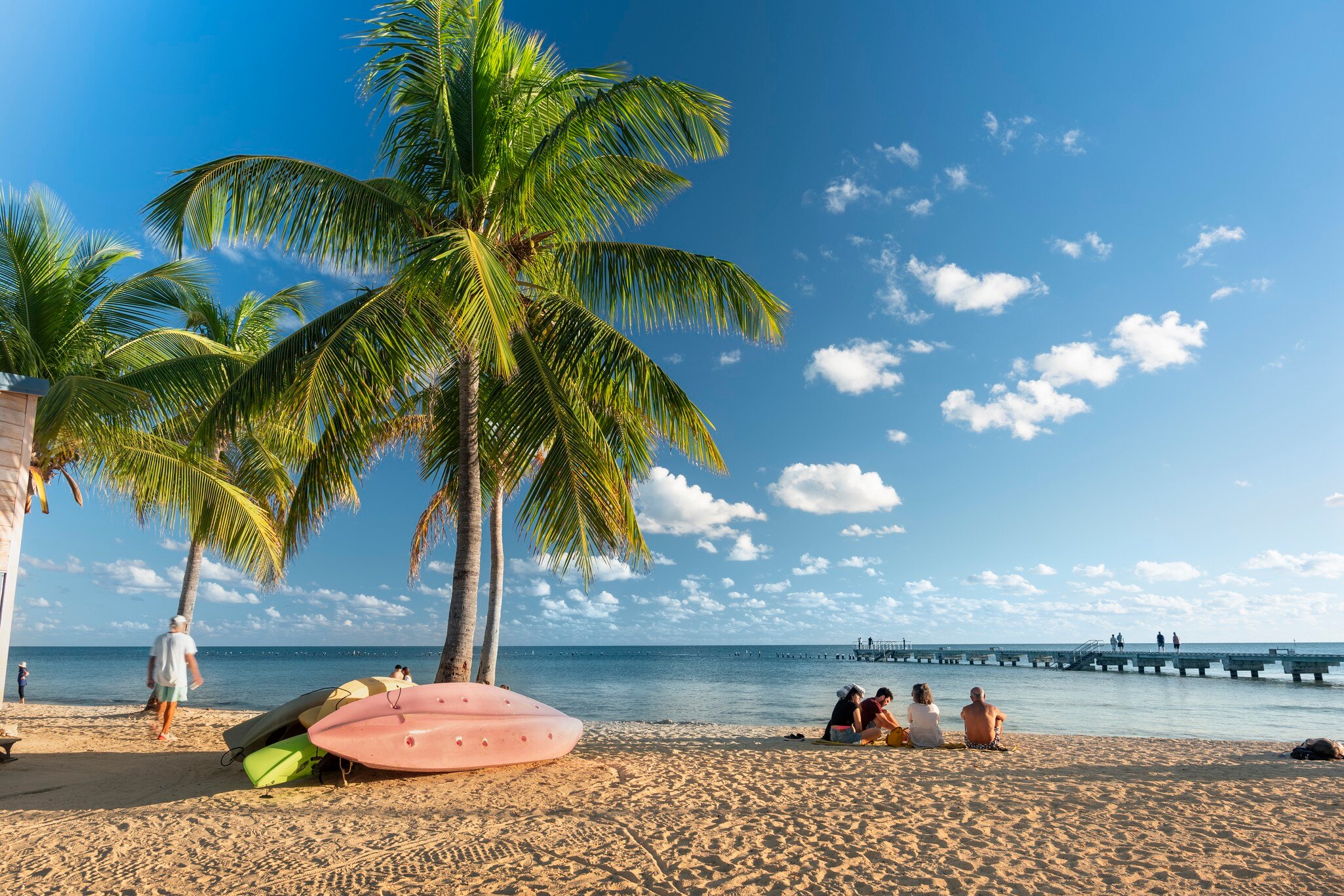 Key West, Florida - December 4, 2019:  People gather on the sand of Smathers Beach to watch the sunset in tropical Key West Florida USA