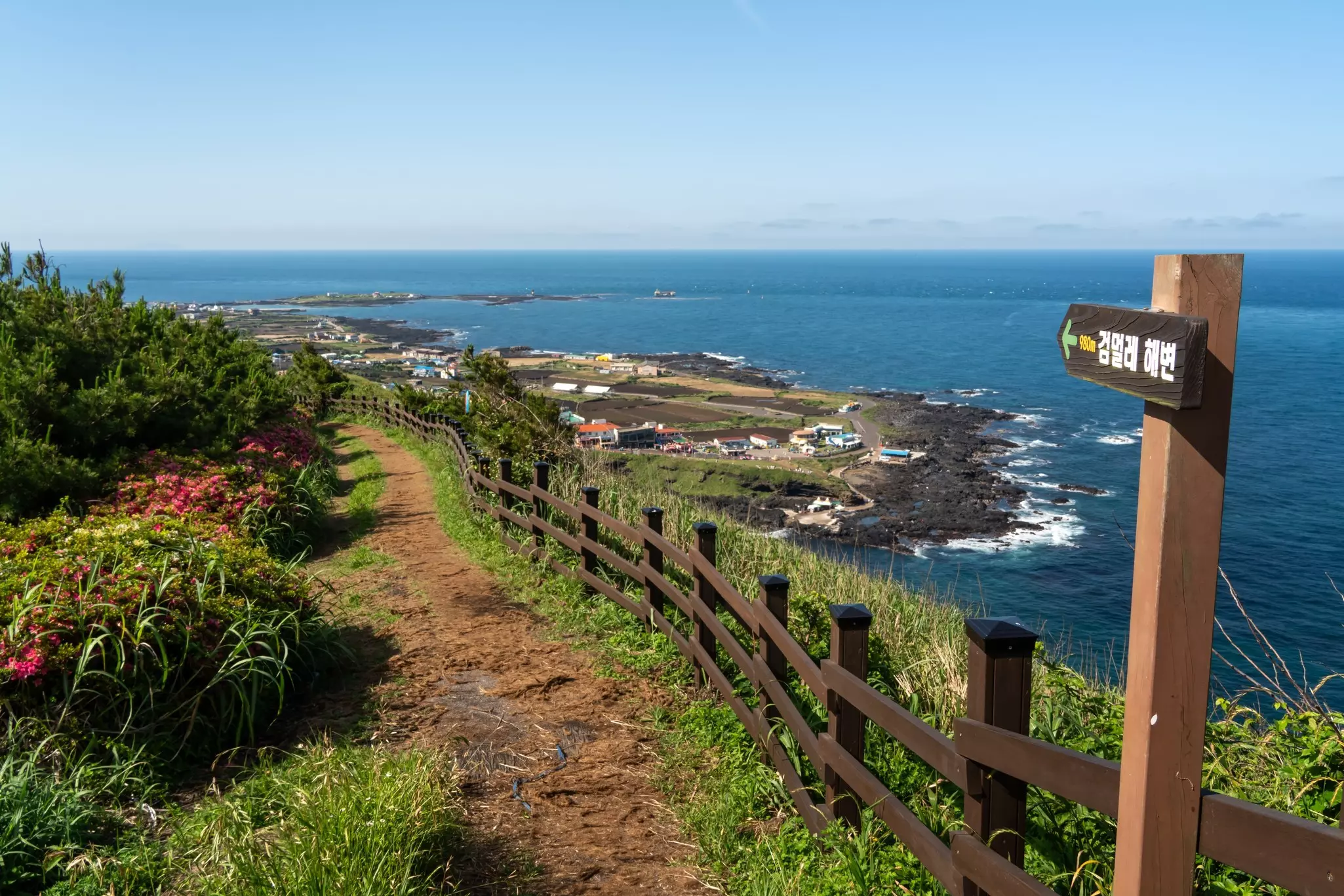 A coastal pathway leading towards a small island settlement