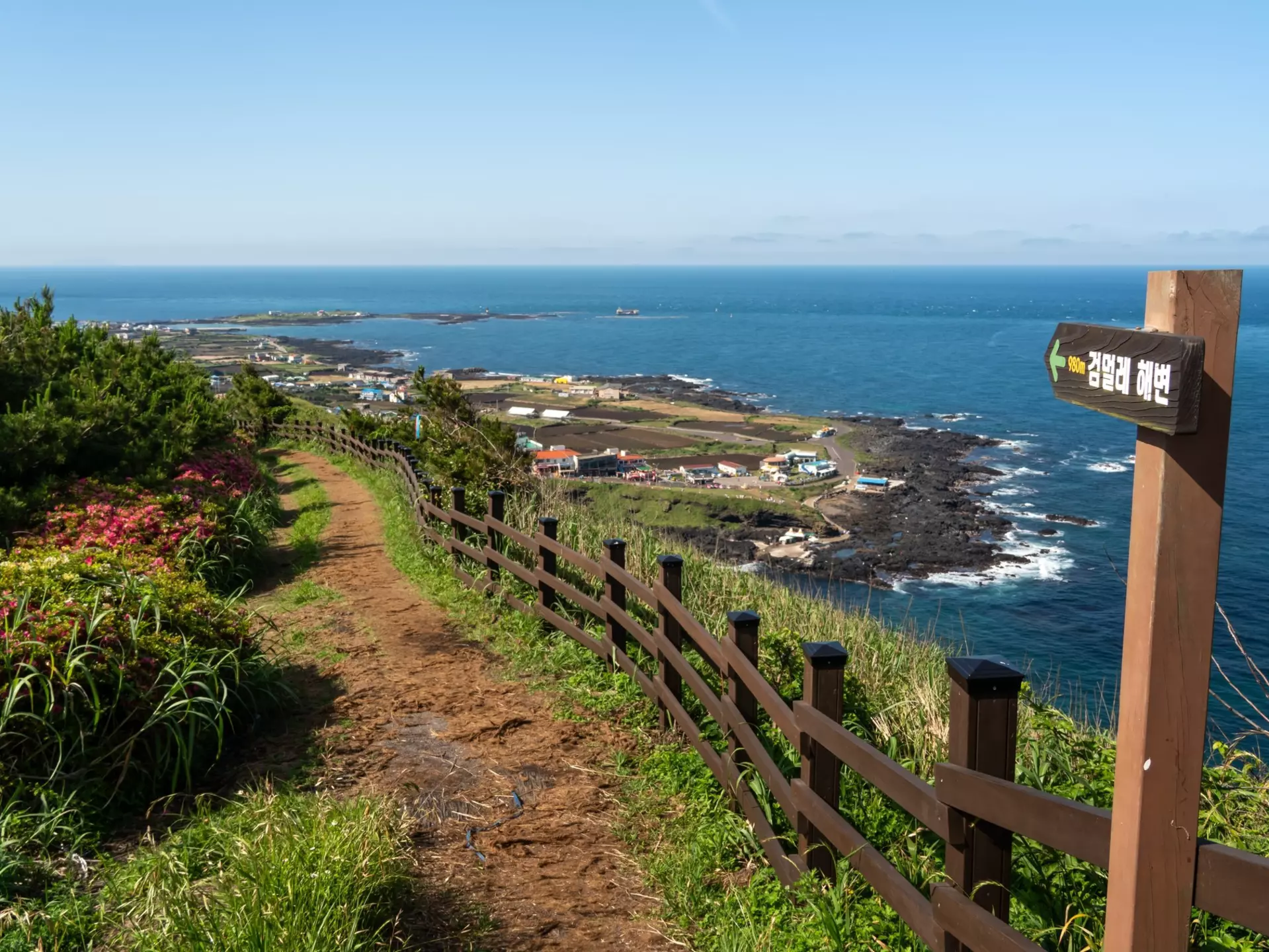 A coastal pathway leading towards a small island settlement