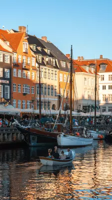 Boats in a harbor with buildings along the side.