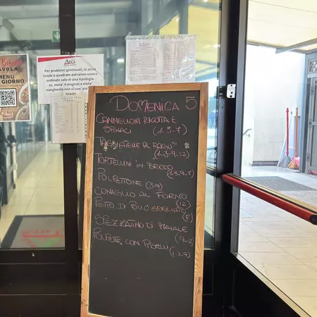 A chalkboard with an Italian menu inside a glass entryway