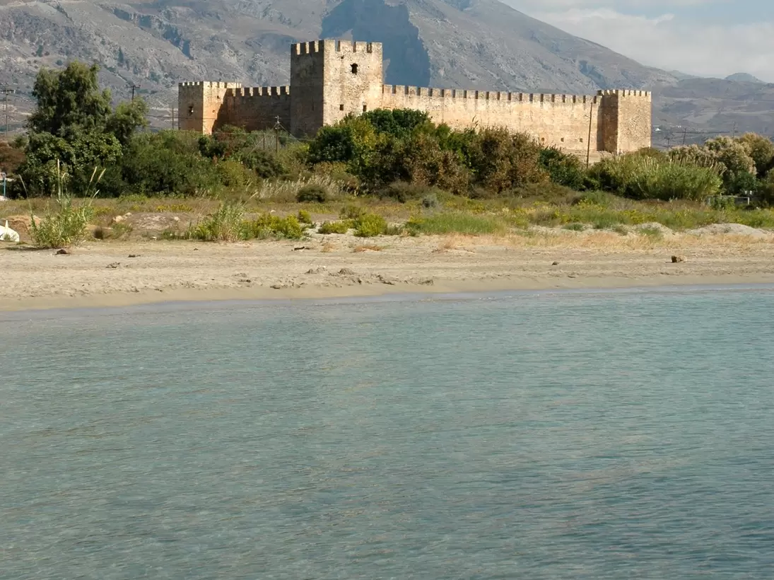 The Frangokastello Castle, with glimmering clear water in the foreground in Crete, Greece.