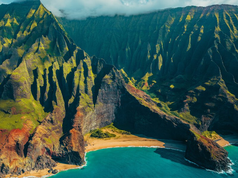 Hawaii Kauai Na Pali coast landscape aerial view from helicopter. Nature coastline dramatic mountains with secluded popular tourist attraction beach. USA destination.