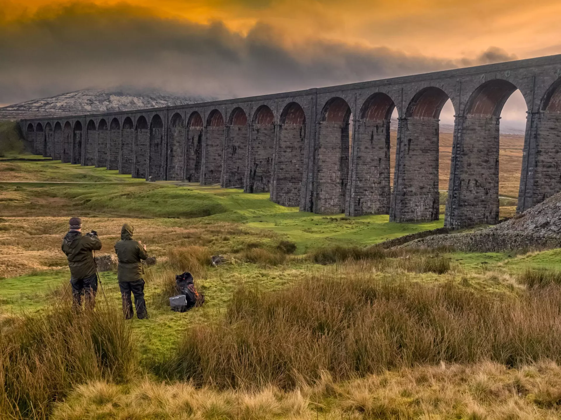 Photographers capturing the Ribblehead Viaduct on the Settle-Carlisle railway in low light.