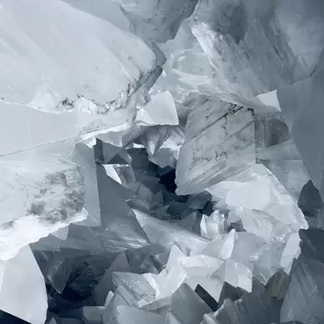 Geometric shapes of a large white crystal in a cave.