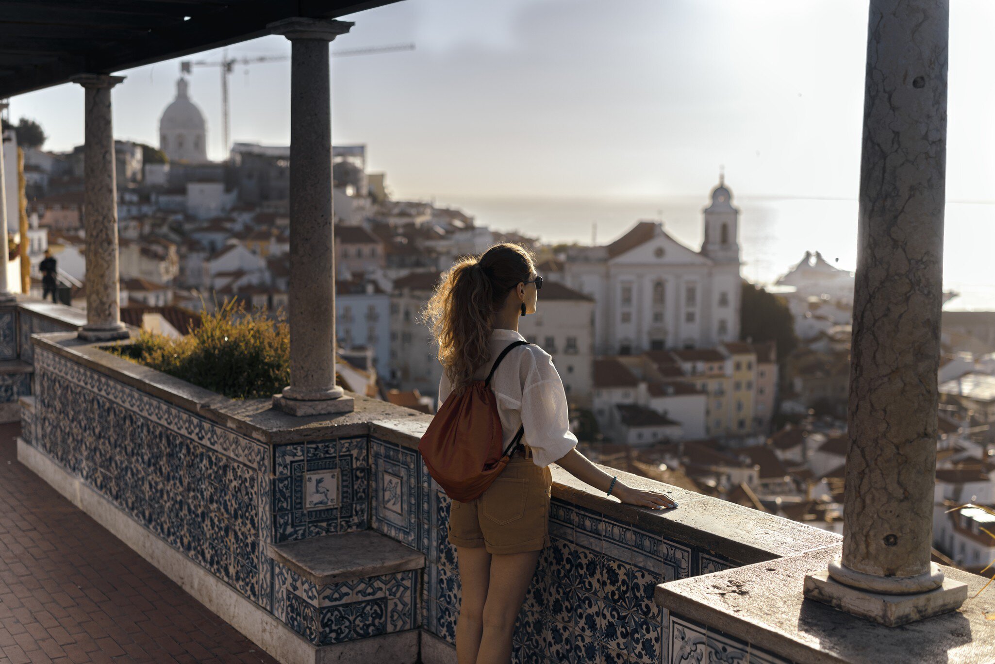Scene with a female tourist who is walking on the street of Iberic city and poses in a famous, most recognizable places with breathtaking view