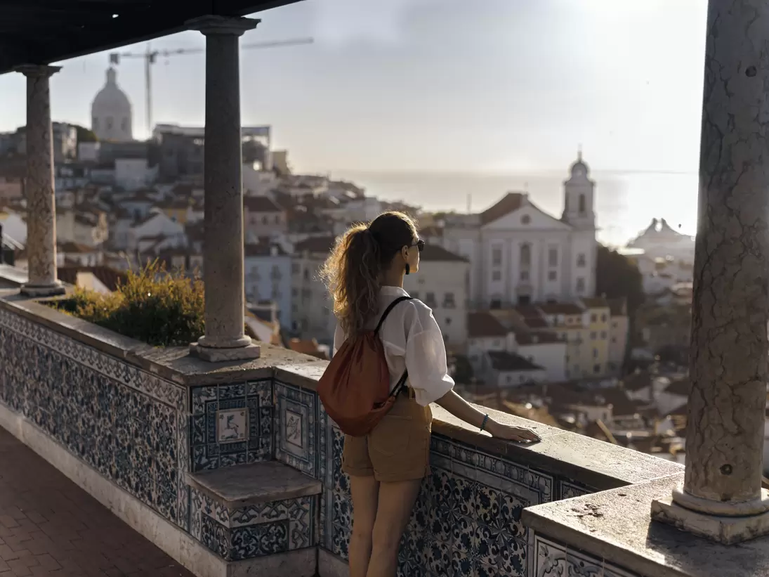 Scene with a female tourist who is walking on the street of Iberic city and poses in a famous, most recognizable places with breathtaking view
