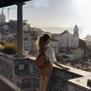 Scene with a female tourist who is walking on the street of Iberic city and poses in a famous, most recognizable places with breathtaking view