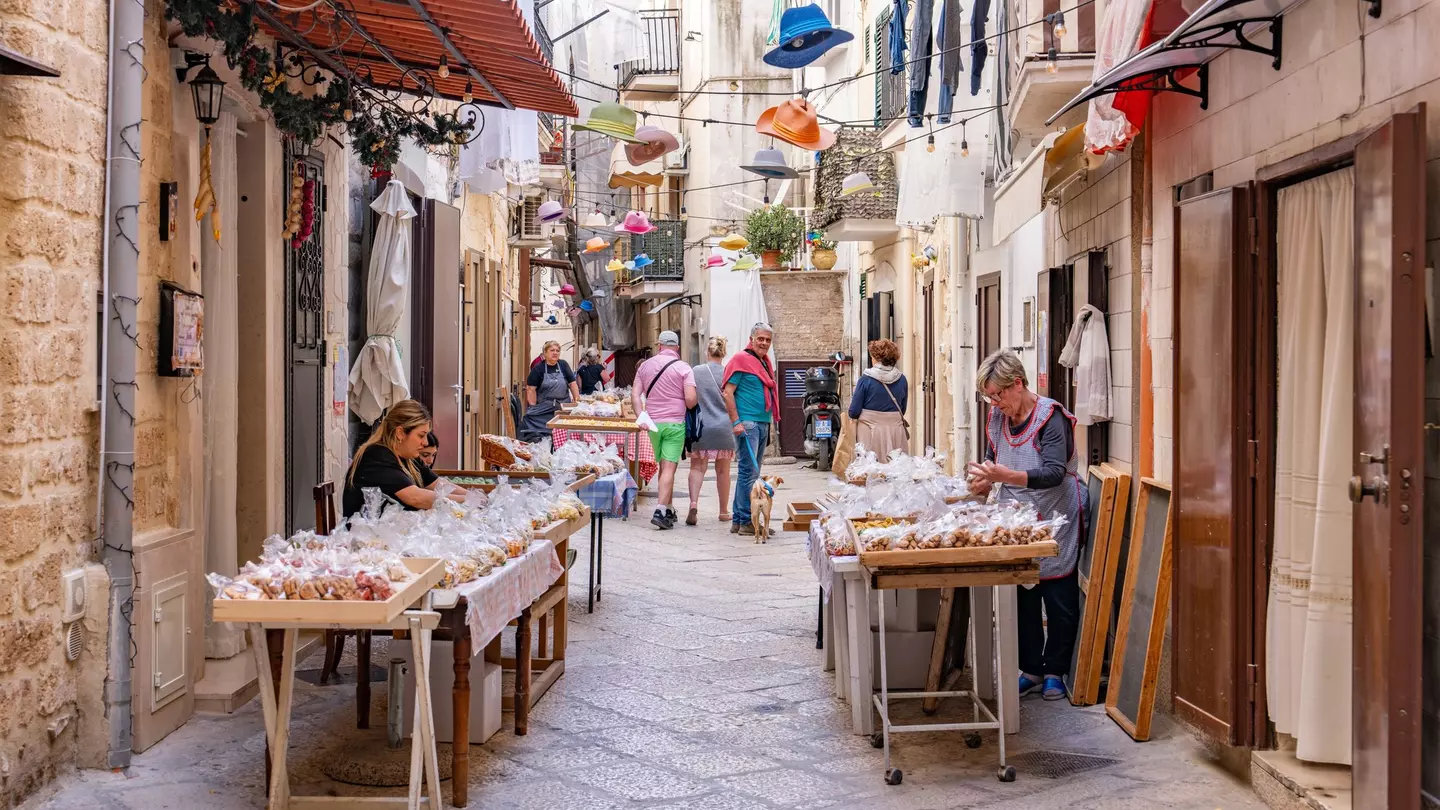 Local women selling authentic hand made pasta in the old town of Bari, Italy