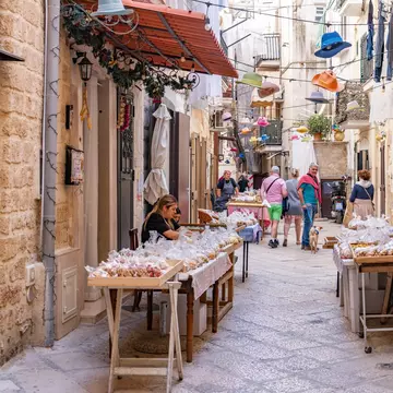 Local women selling authentic hand made pasta in the old town of Bari, Italy