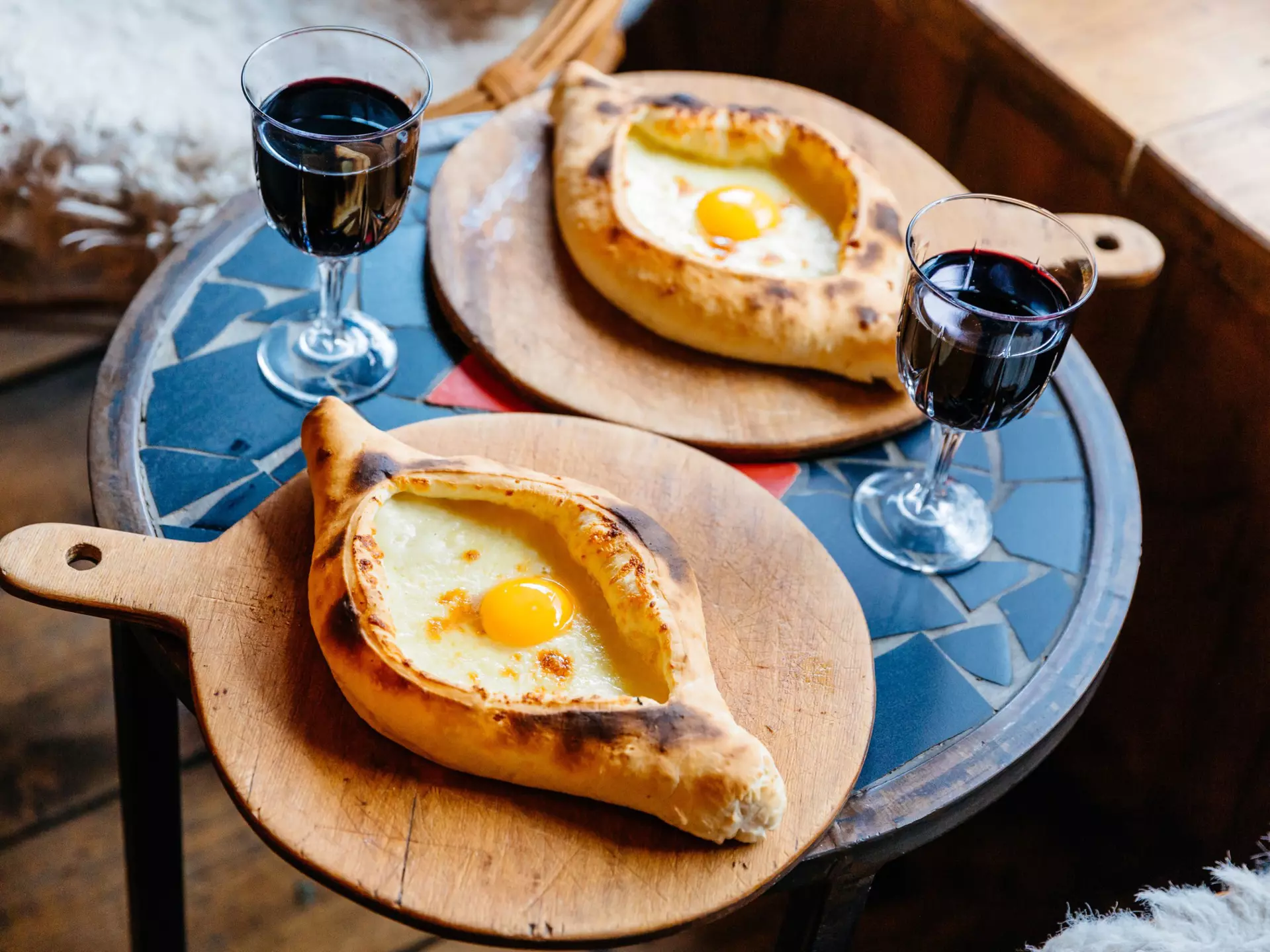 A table with Khachapuri and red wine in Tbilisi, Georgia.