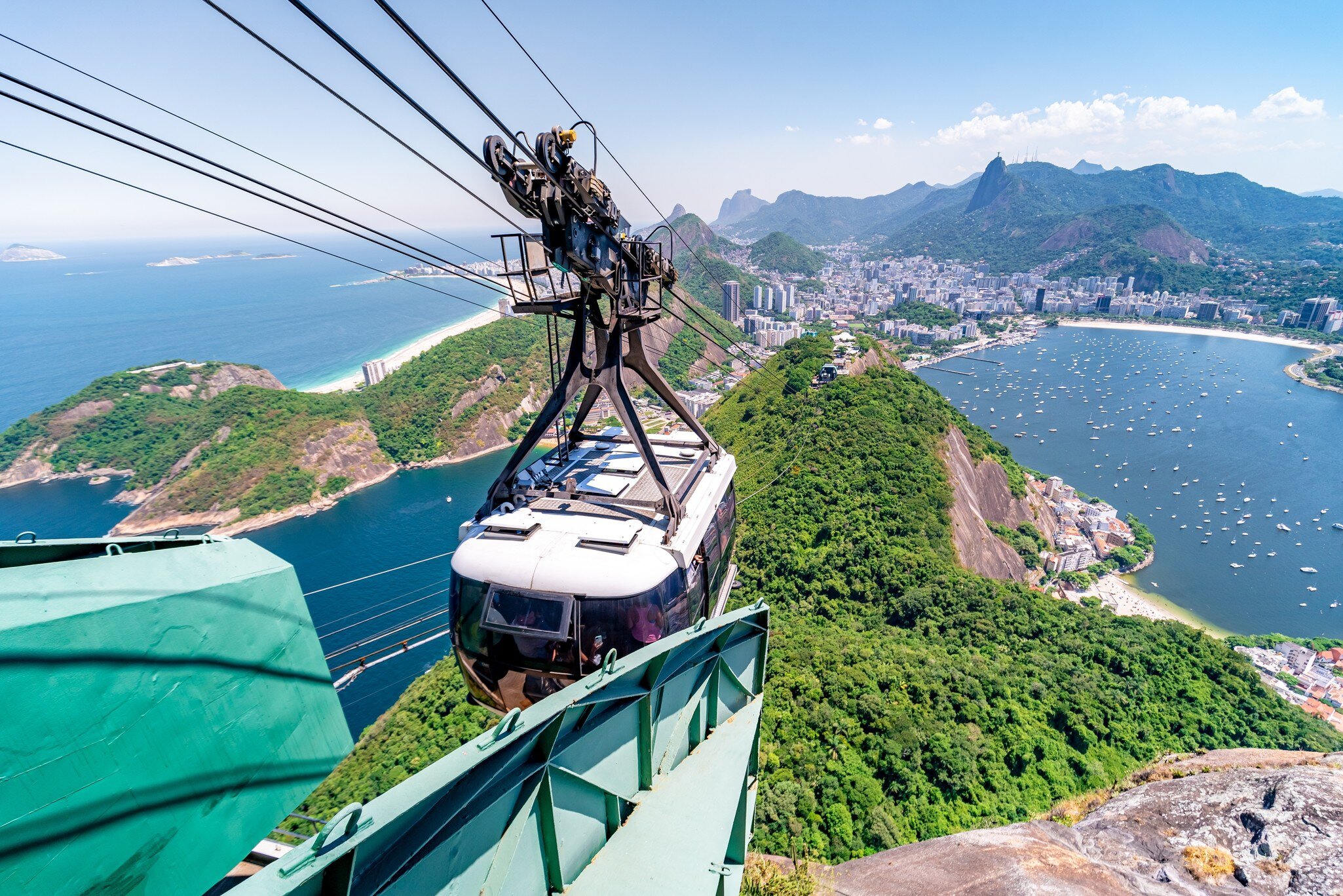 View of the cable car crossing over to Sugarloaf Mountain with the city of Rio de Janeiro in the background in Brazil.