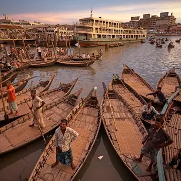 July 2009: Passengers and rowers on rowboats at the Sadarghat launch terminal.
1192792519
asia, bangladesh, boat, business, canoe, city, city life, climate change, climate refugees, coastline, commercial dock, crowd, delta, dhaka, ferry, ganges river, group of people, human rights, landscape, men, natural disaster, nautical vessel, old, outdoor, passenger, people, pier, population explosion, port, poverty, river, rowboat, scene, sea, ship, terminal, tourism, traditional, transportation, travel, view, water, women, work