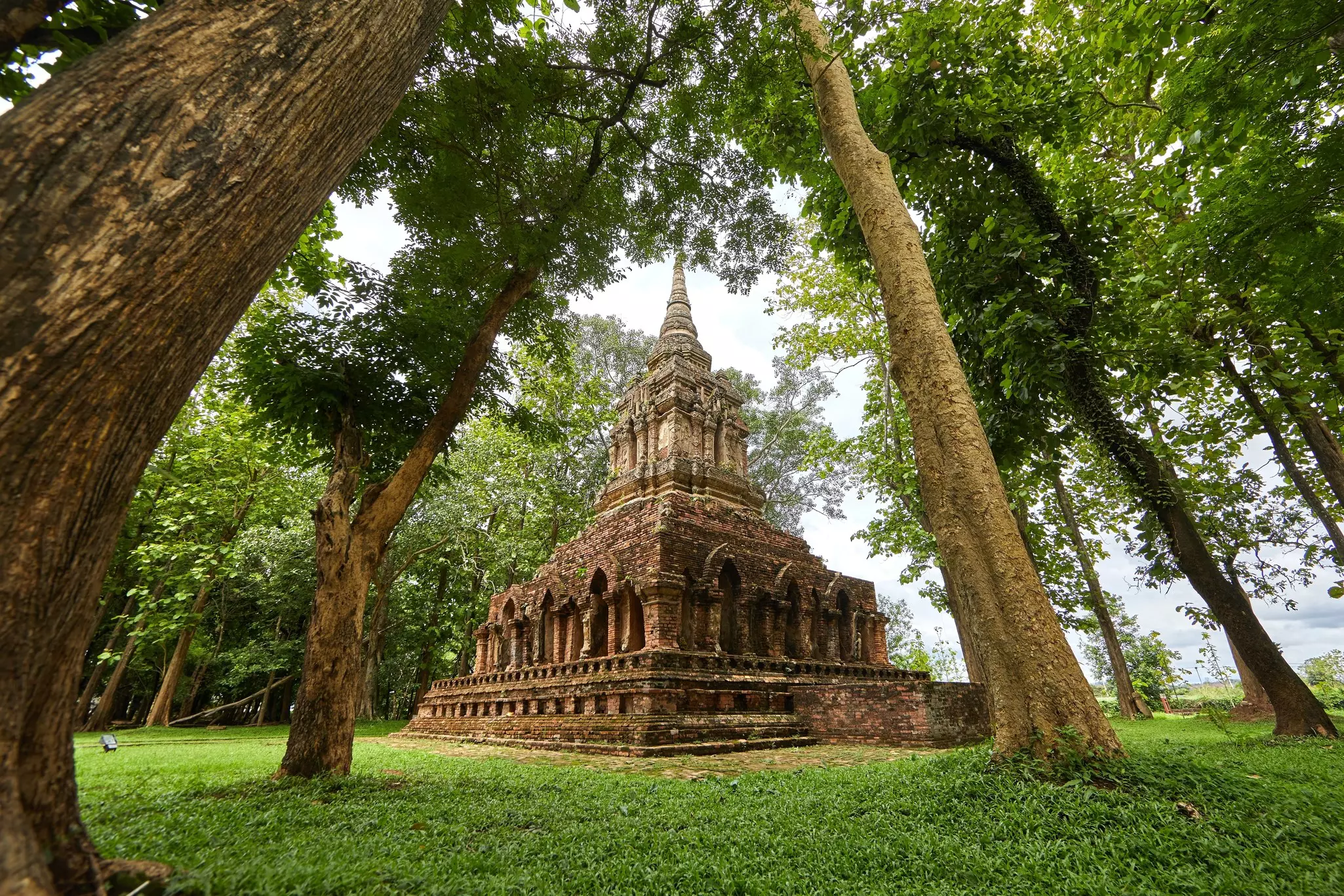 An ancient brick temple surrounded by woodland.