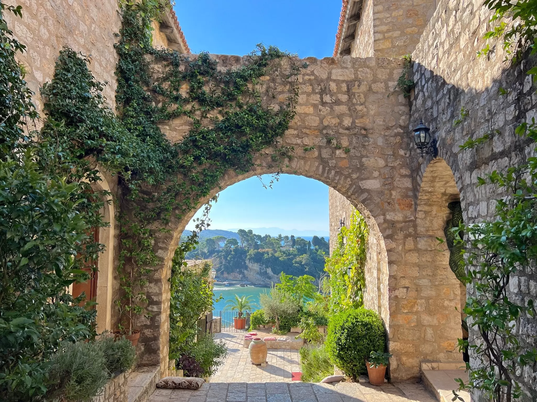 An ancient patio lined with plants overlooked a waterfront; Ulcinj, Montenegro