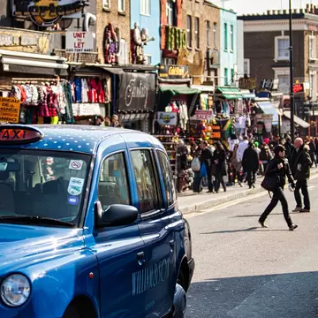 London, United Kingdom - March 20 2009 : Visitors stroll through Camden Market while a blue taxi passes on the street under a clear sky in London United Kingdom., License Type: media, Download Time: 2025-07-28T19:57:13.000Z, User: katelyn.perry_lonelyplanet, Editorial: true, purchase_order: 65050 - Digital Destinations and Articles, job: wip, client: wip, other: Katelyn Perry