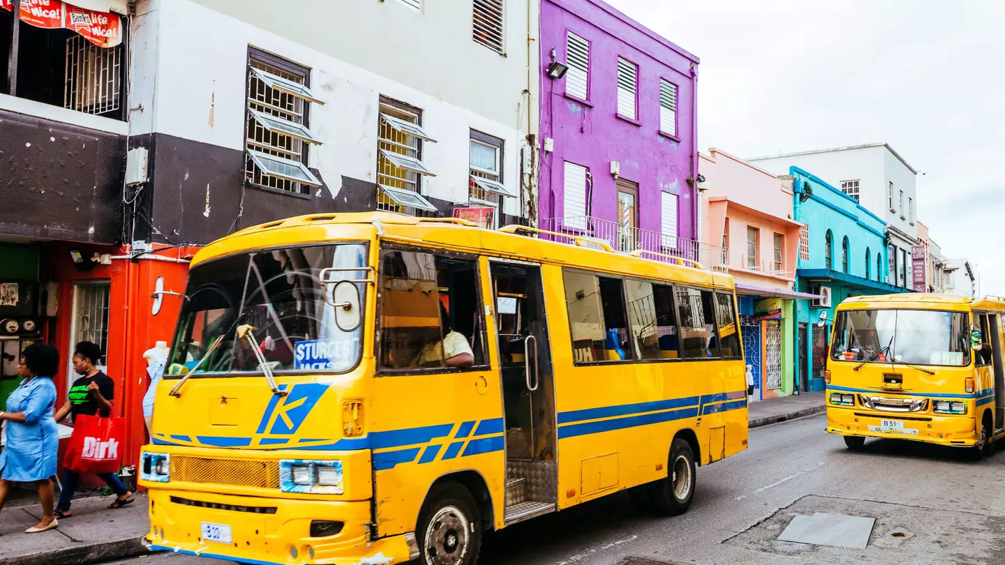 Everyday traffic scene with local yellow buses in the streets of old Bridgetown, Barbados
