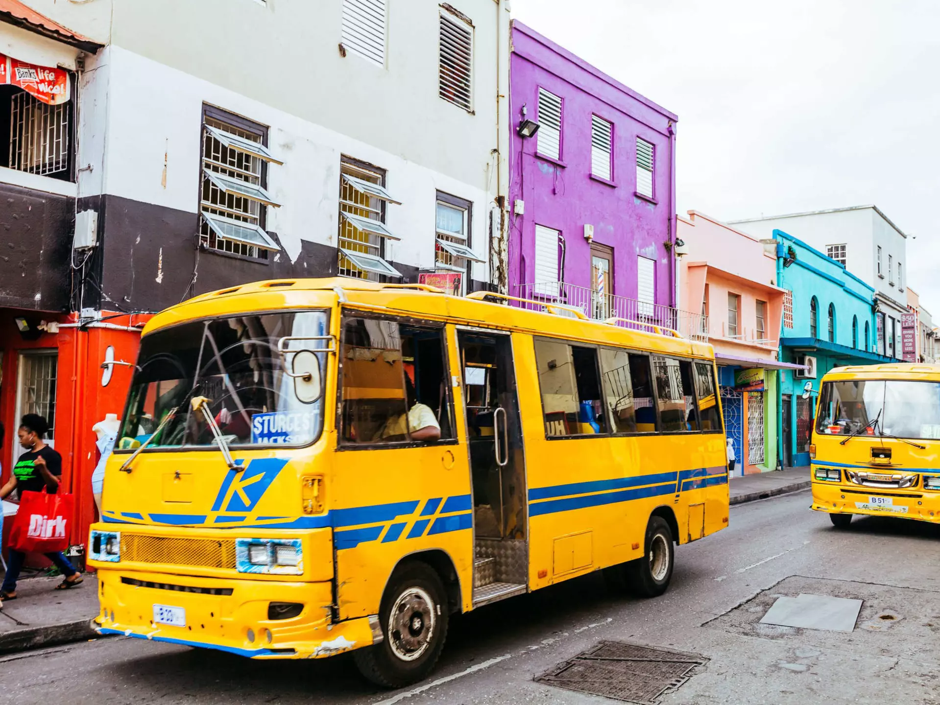 Everyday traffic scene with local yellow buses in the streets of old Bridgetown, Barbados