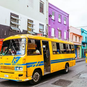 Everyday traffic scene with local yellow buses in the streets of old Bridgetown, Barbados