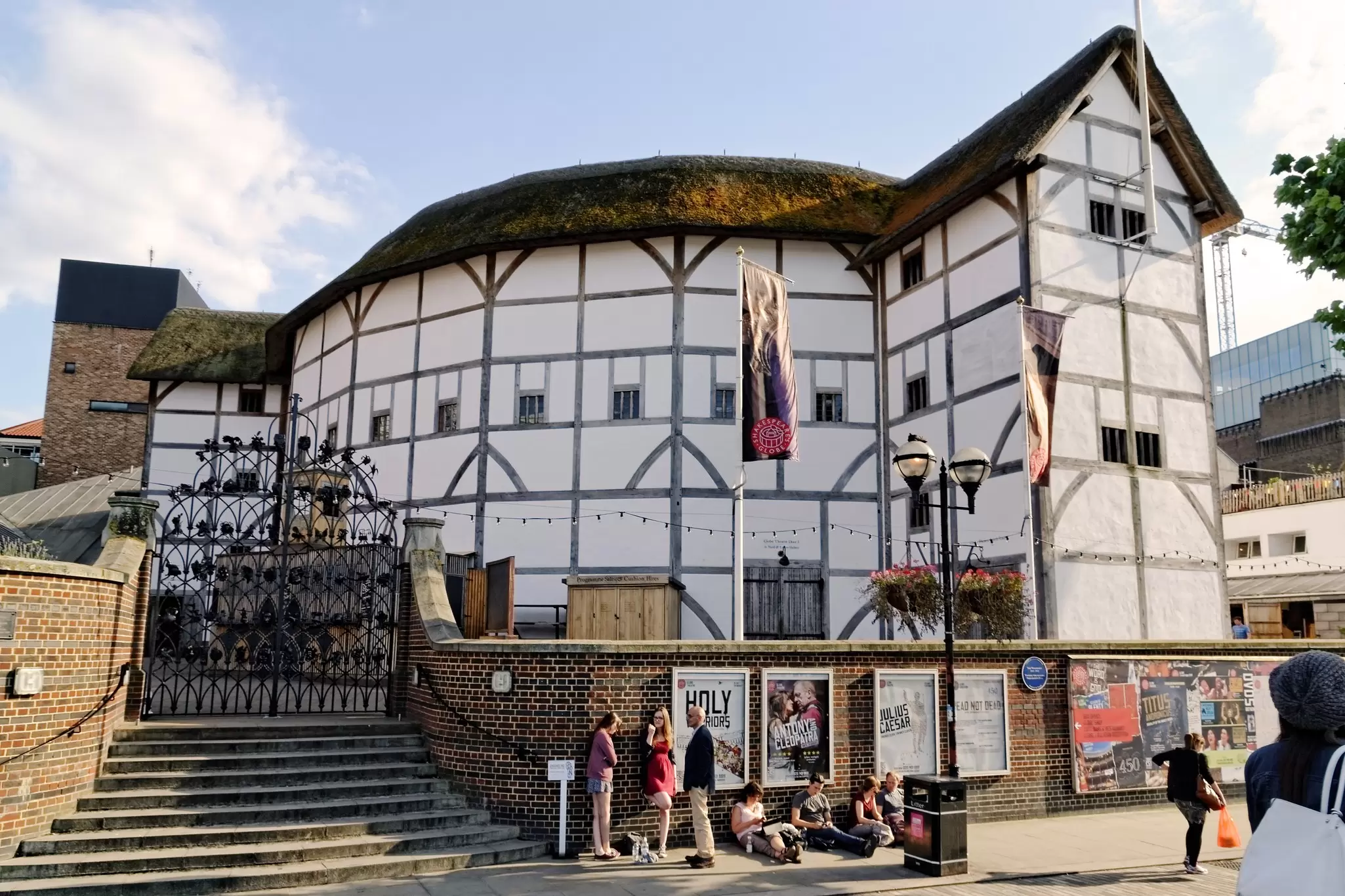 People sitting in front of Shakespeare's Globe in London, UK.