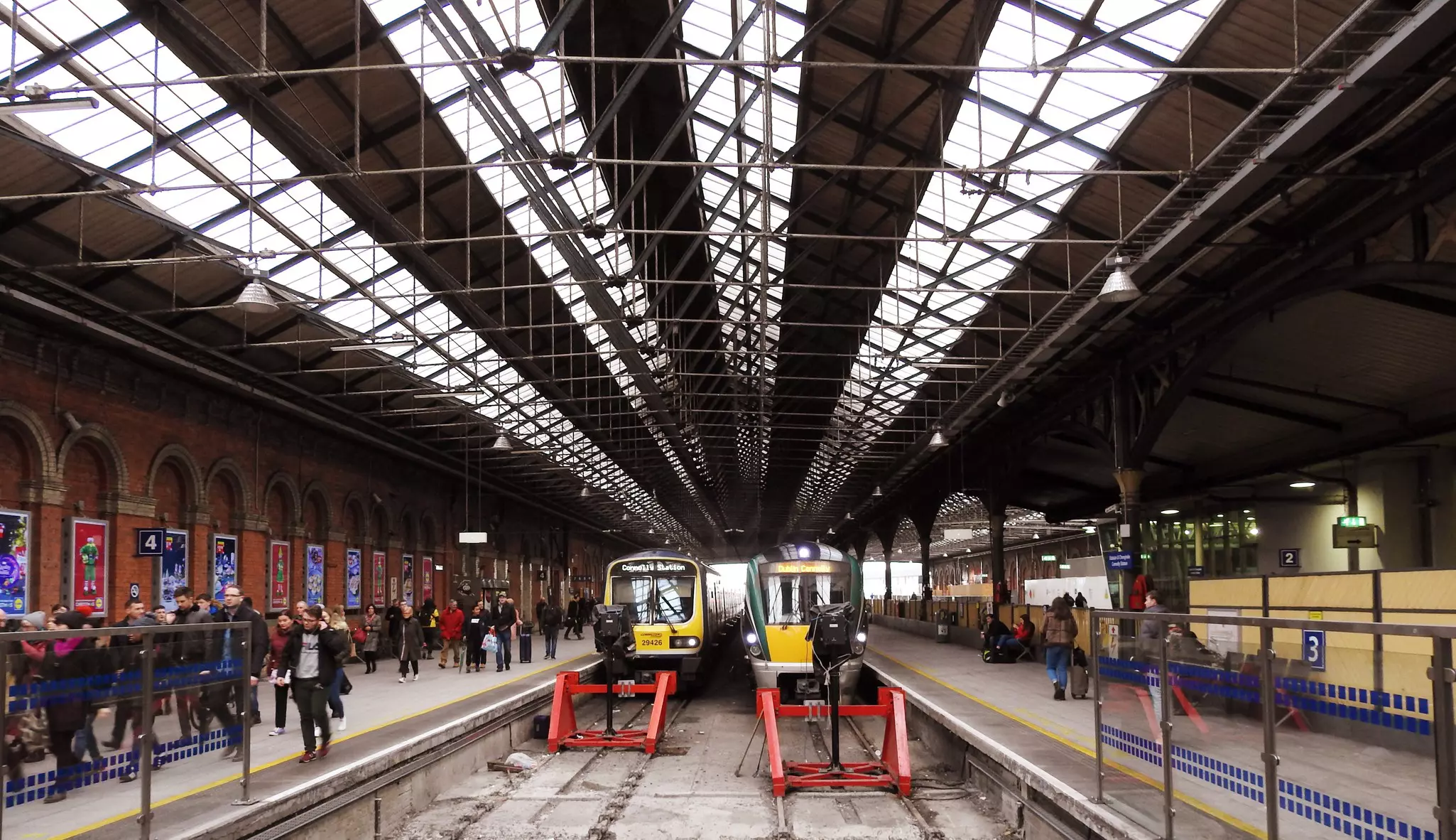 Trains arrive in Dublin's Connolly Train Station with passengers on the platform.