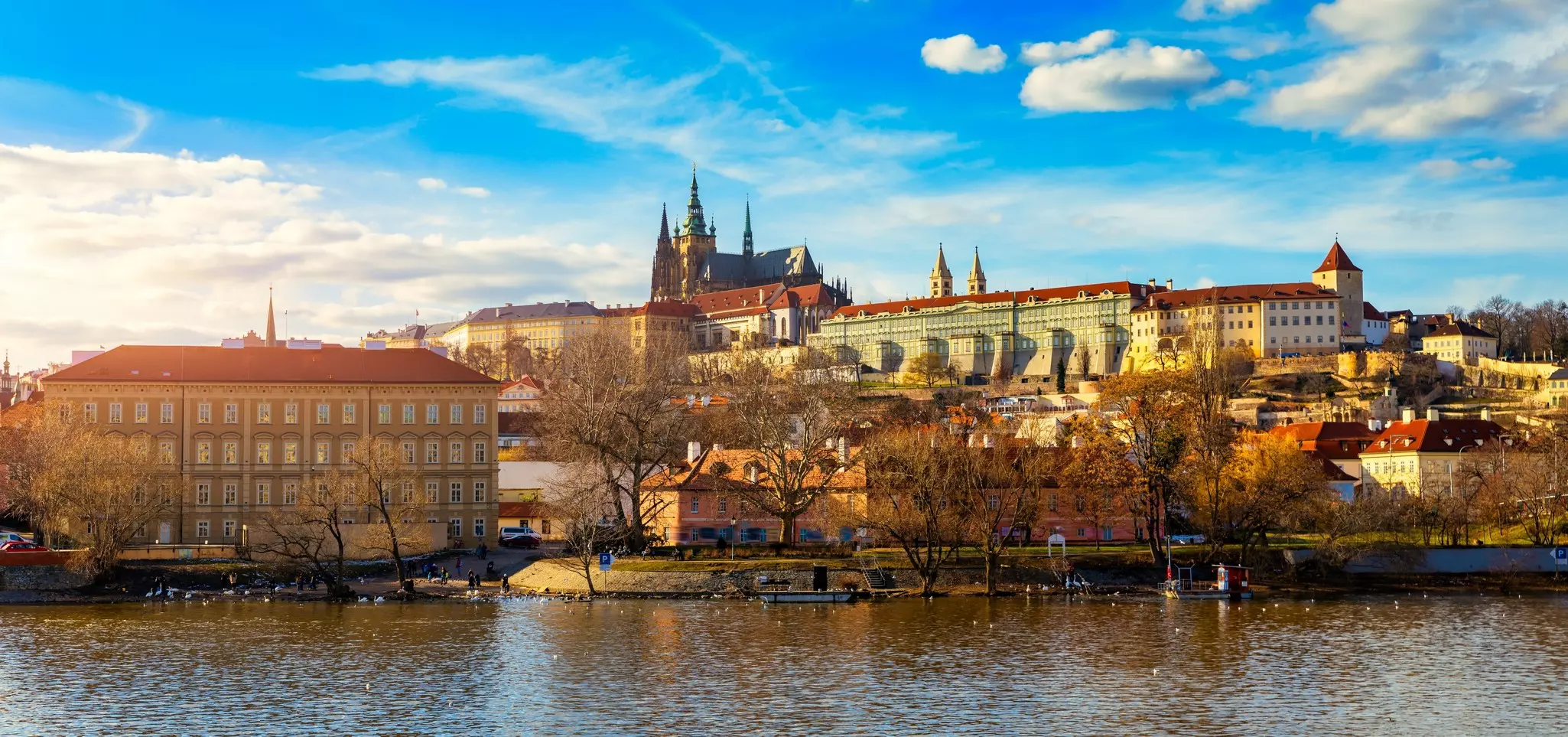 Skyline of Prague, castle and river in foreground. 