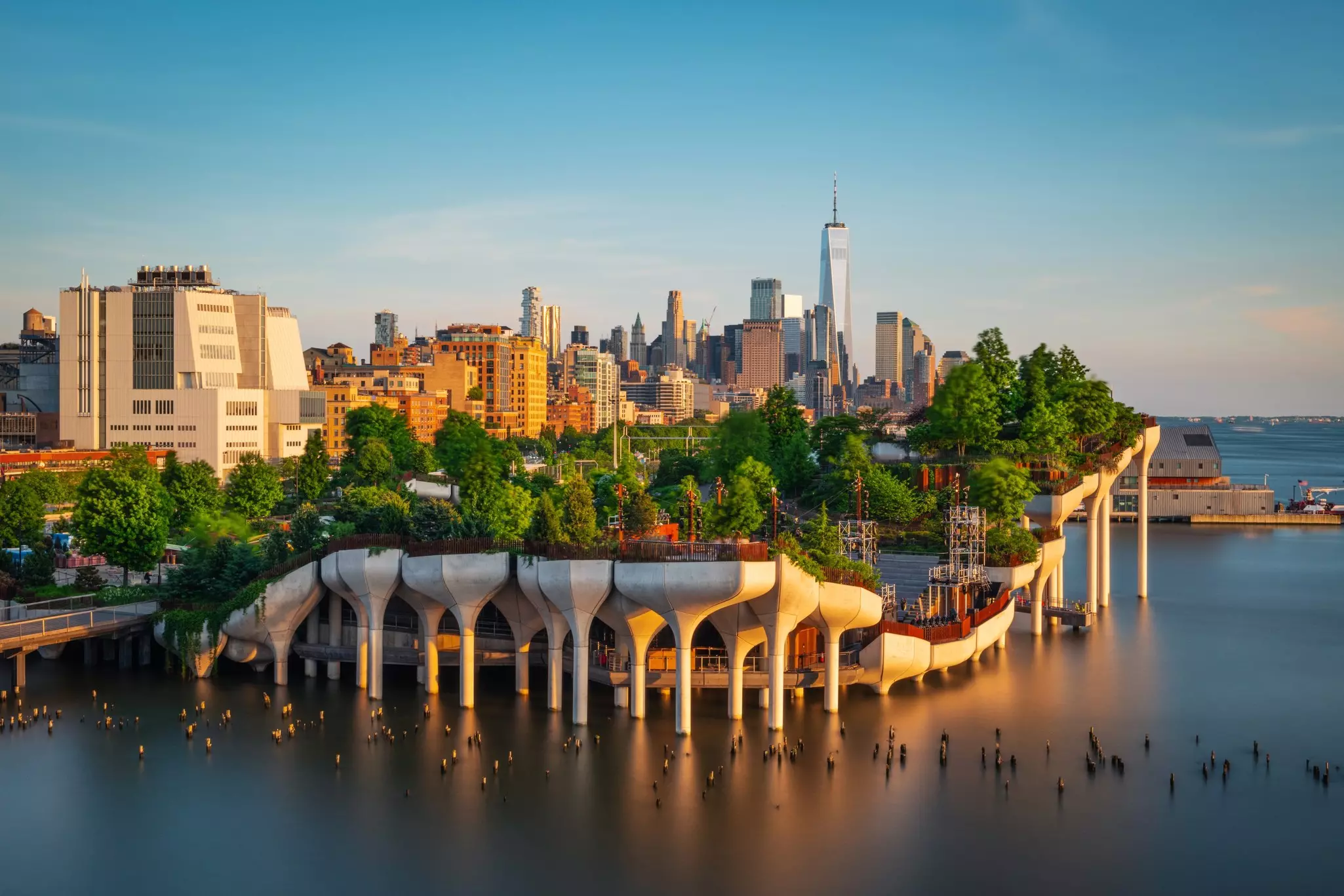 An artificial park on a river with a city skyline in the background 