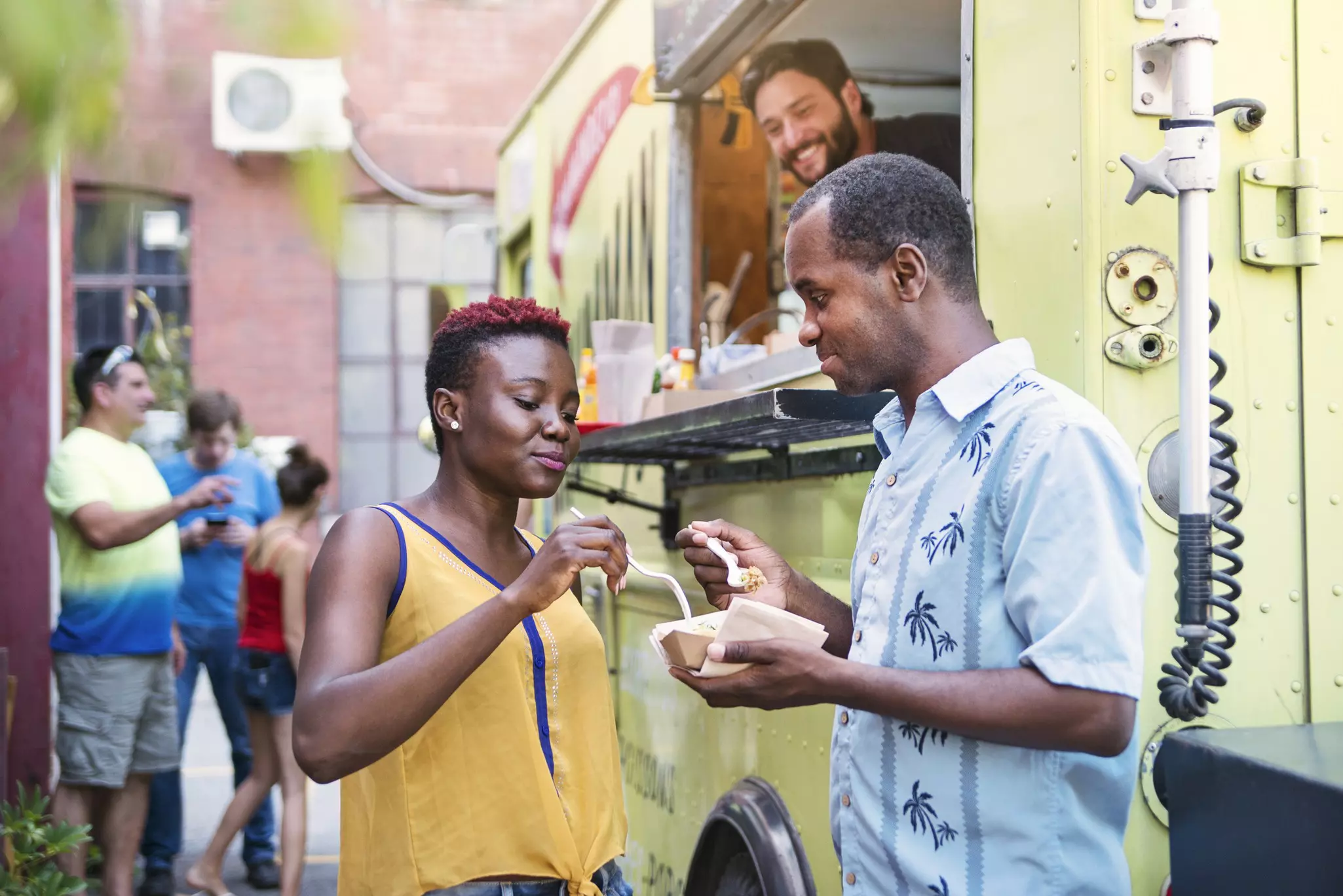 African-american couple enjoying food from a food truck in Montreal, Canada.