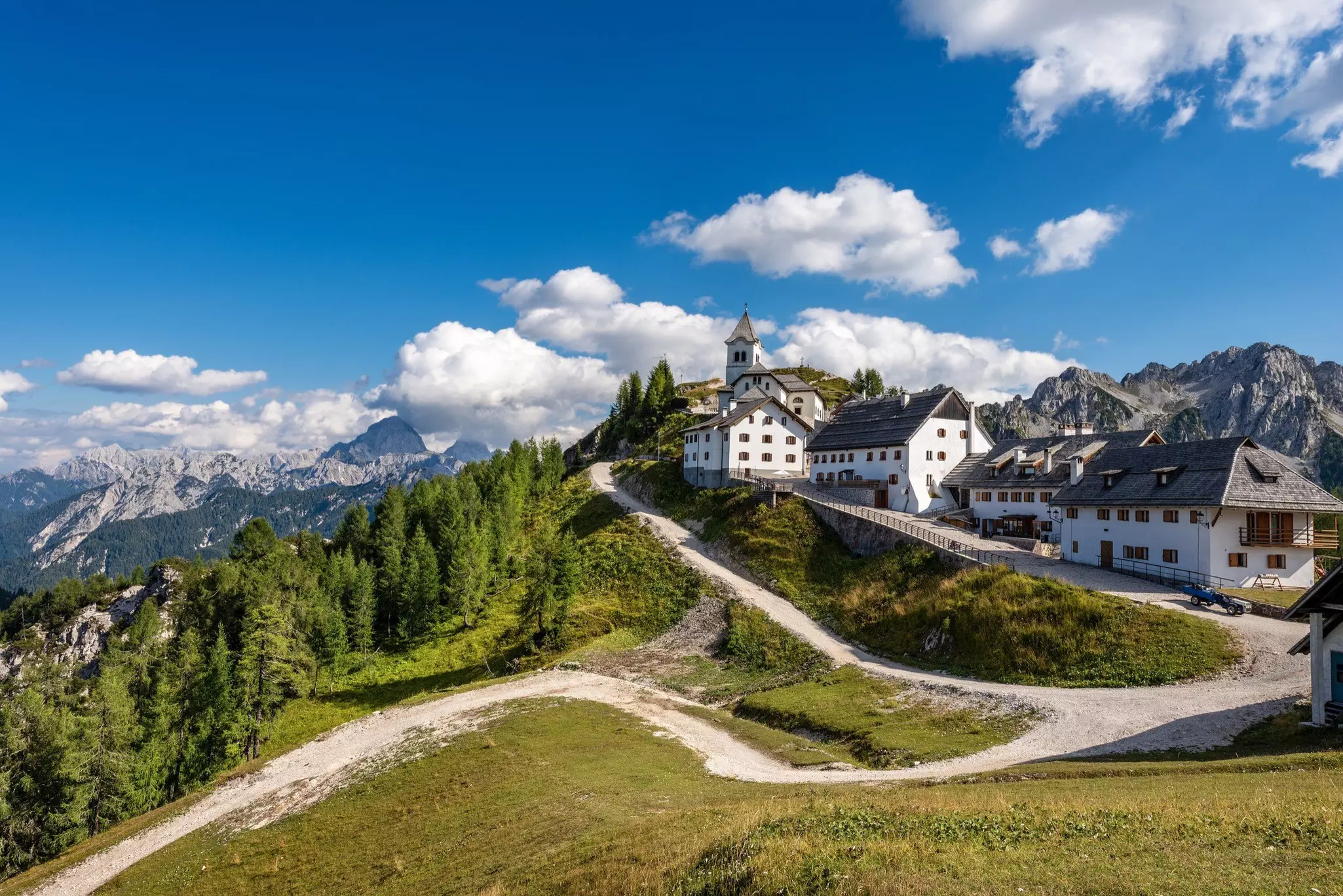 The village of Monte Santo di Lussari is mirrored by the peak of Mangart in the Julian Alps © Alberto Masnovo / Shutterstock