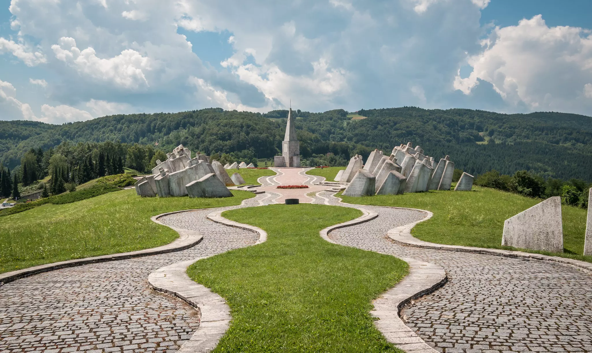 A neat memorial ground with large white stones and a church at the end of a path