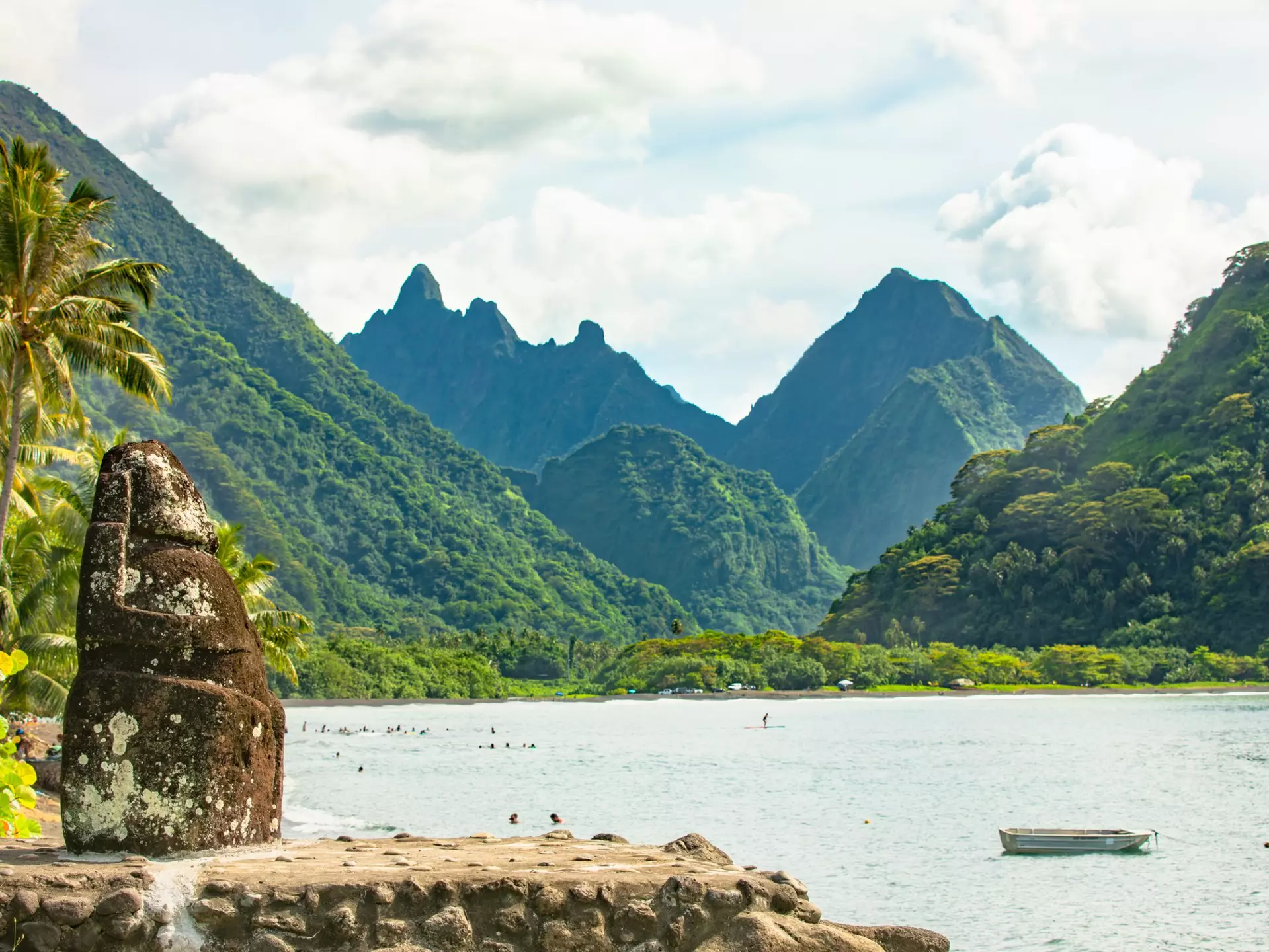 Mountains rising out of the ocean with a rock creation in the foreground