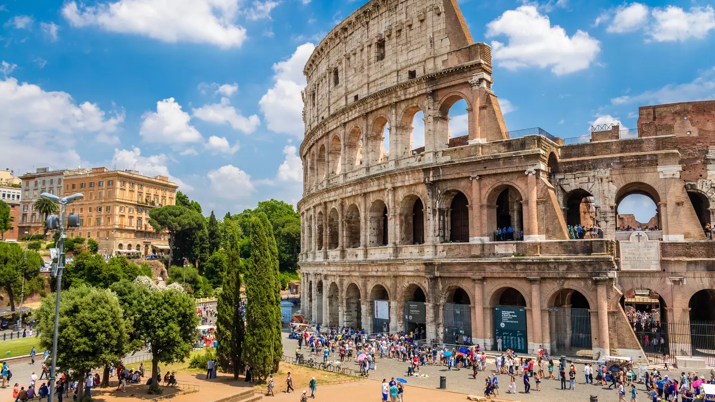 Crowd of visitors outside the Colosseum on a sunny day.
