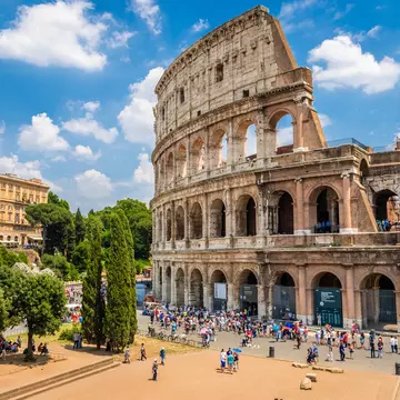 Crowd of visitors outside the Colosseum on a sunny day.
