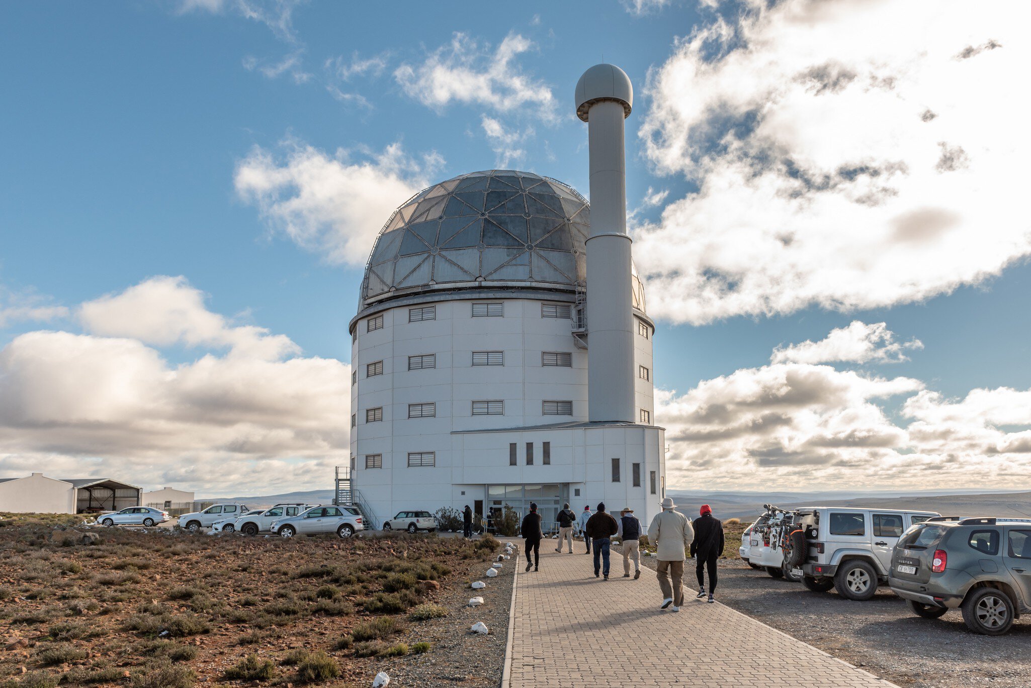SUTHERLAND, SOUTH AFRICA, AUGUST 7, 2018: Building of the SALT 11-meter telescope at the South African Astronomical Observatory near Sutherland. Vehicles and tourists are visible