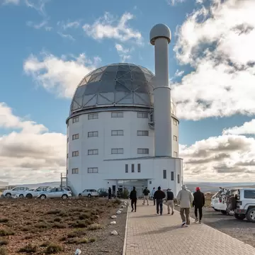 SUTHERLAND, SOUTH AFRICA, AUGUST 7, 2018: Building of the SALT 11-meter telescope at the South African Astronomical Observatory near Sutherland. Vehicles and tourists are visible
