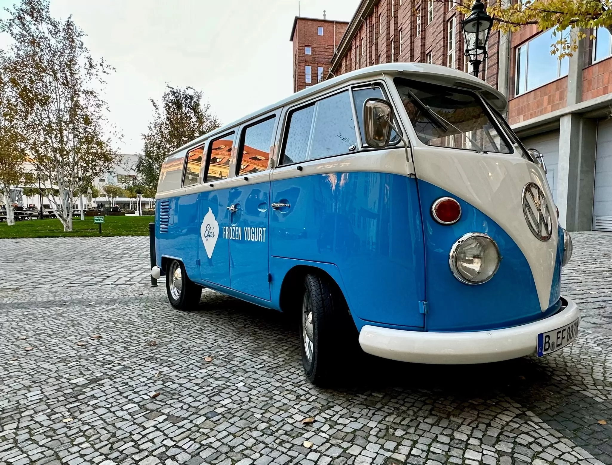 An orange VW camper cruises down a two-lane highway