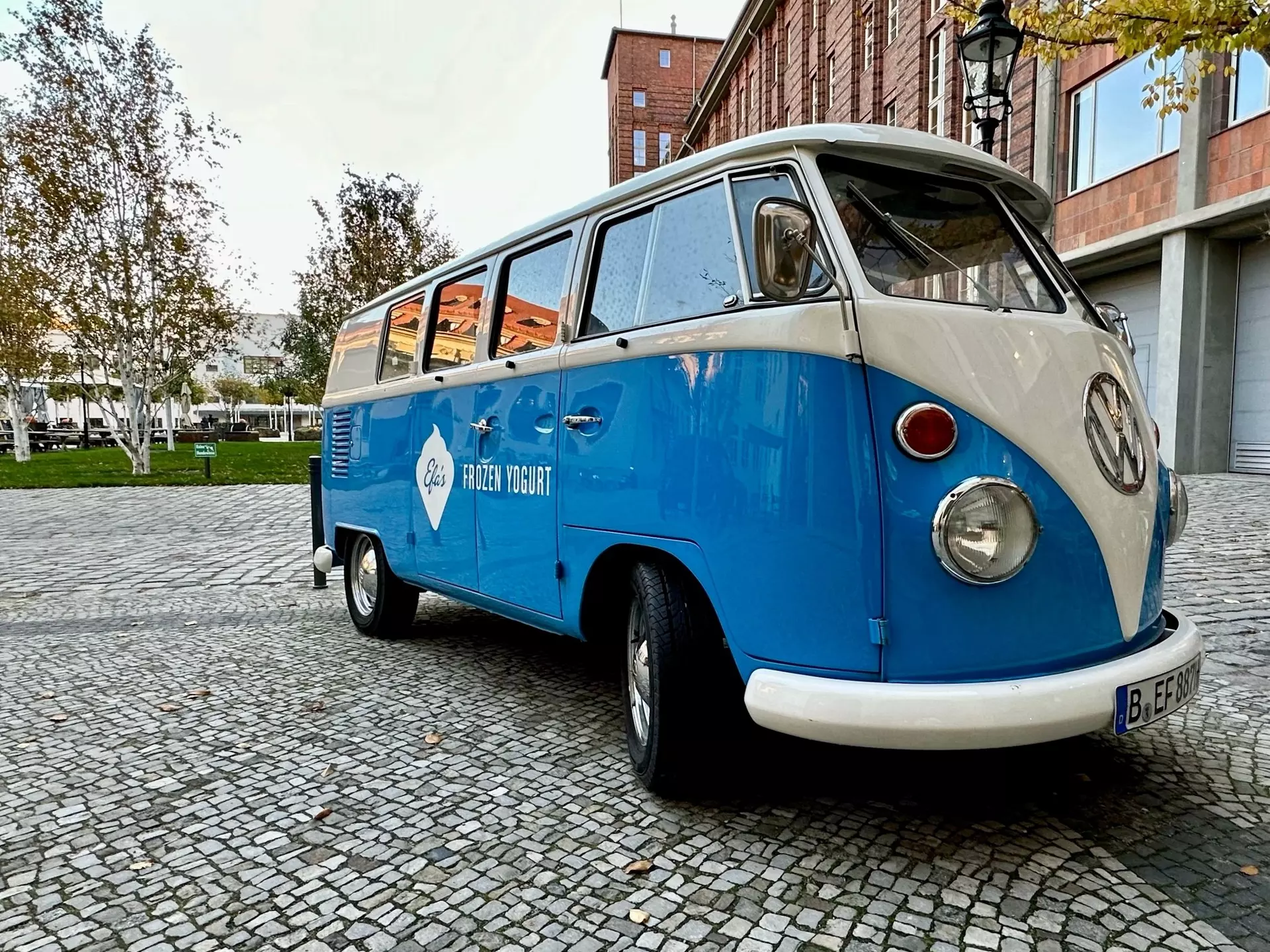 An orange VW camper cruises down a two-lane highway