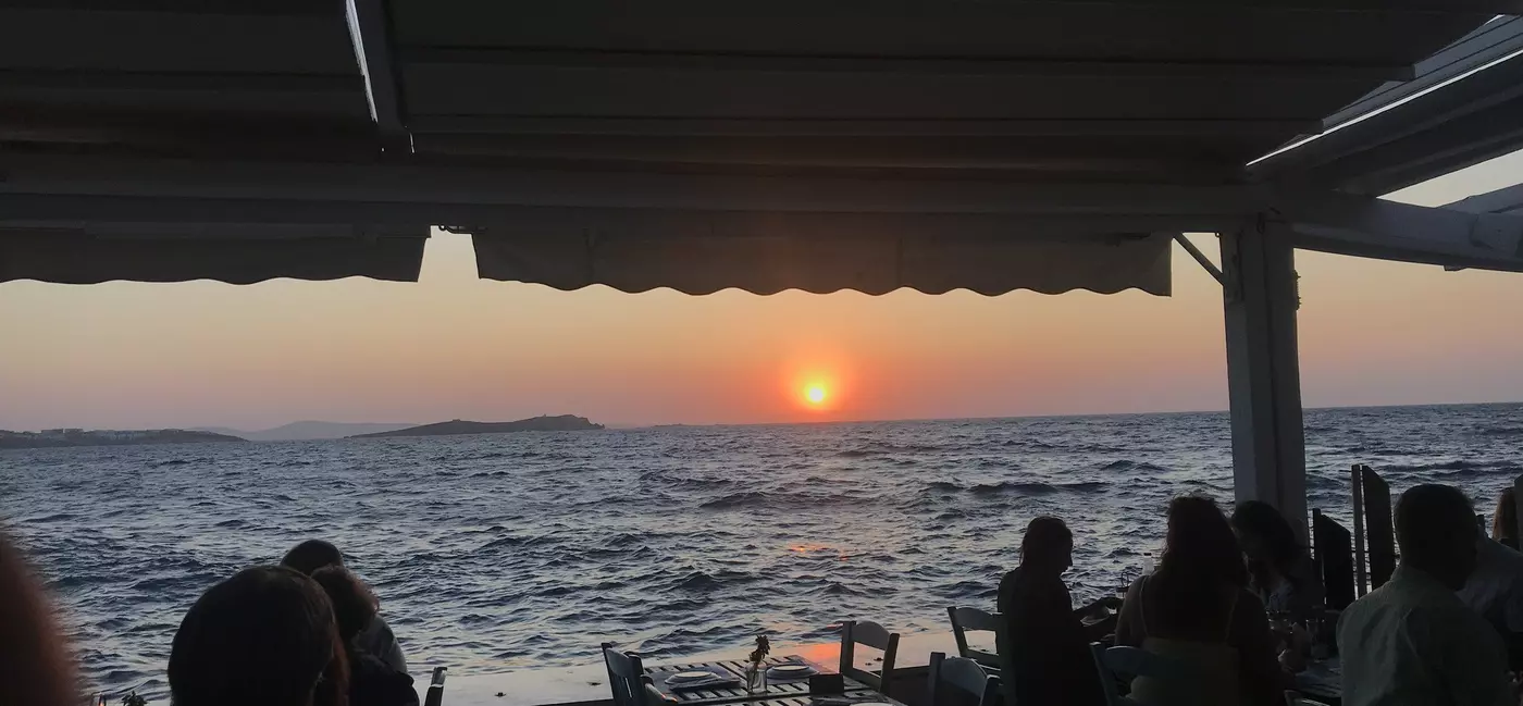 A sunset over sea viewed from a restaurant terrace